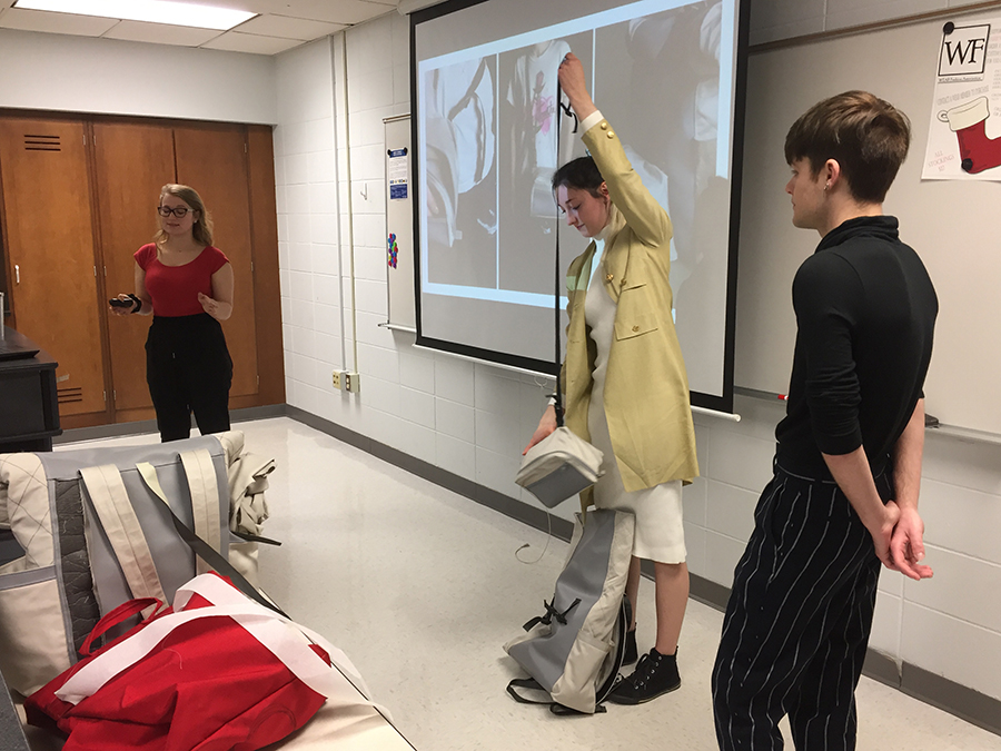 Student Cambria Sinclair, in center, shows how the Lifestyle Backpack converts to a travel backpack and crossbody bag.