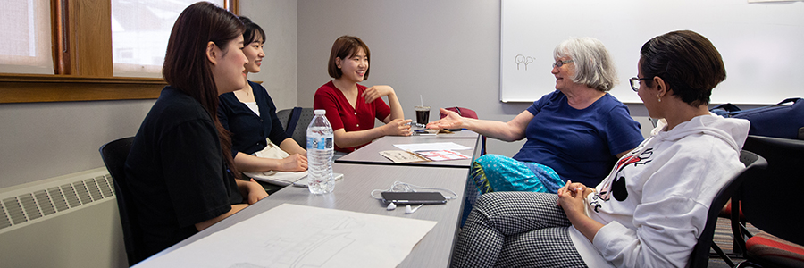 Margee Stienecker, a part-time tutor in the English as a Second Language Institute at UW-Stout, talks with international students during a recent conversation hour on campus. Stienecker said the conversations help broaden peoples’ perspectives and enrich their lives.