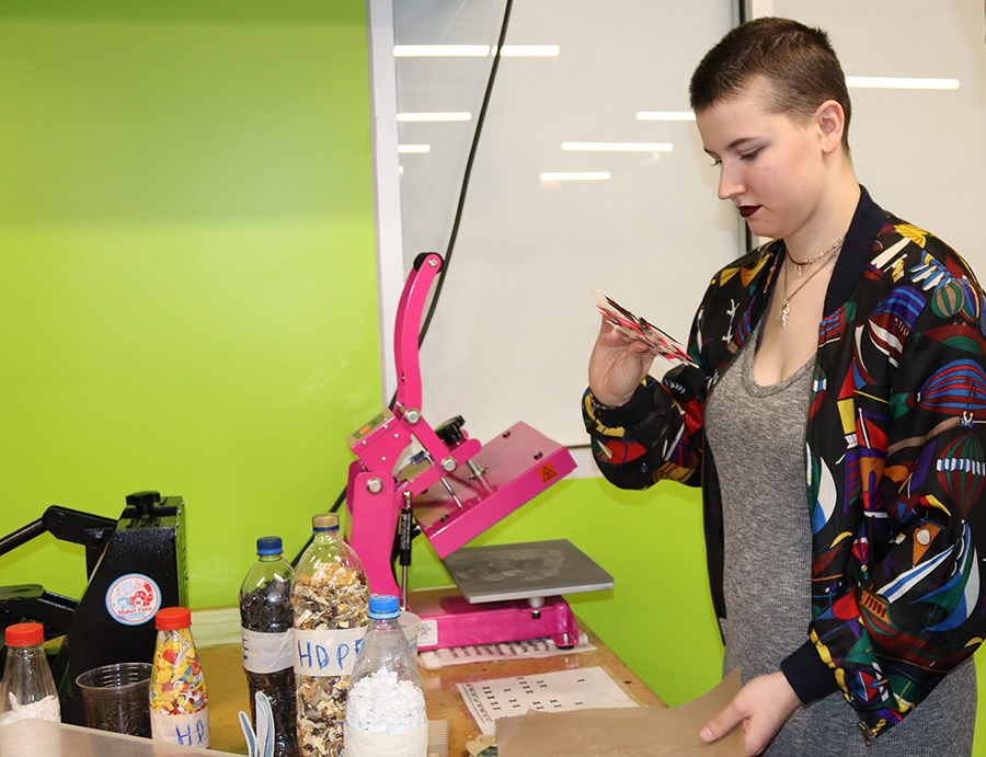 Stephanie Howell uses a heat press to make a plastic sheet.