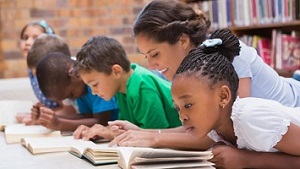 A Teacher assisting her students while reading. 