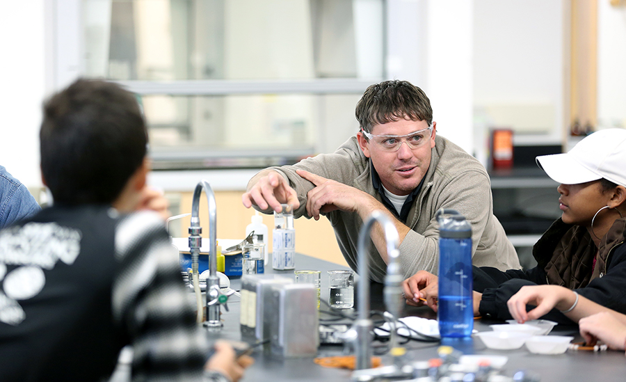 Shane Medin, an instructor in the department of chemistry and physics, talks with Stanley-Boyd Middle School students about water absorption at the 2018 Stout Connects You STEM event at UW-Stout.