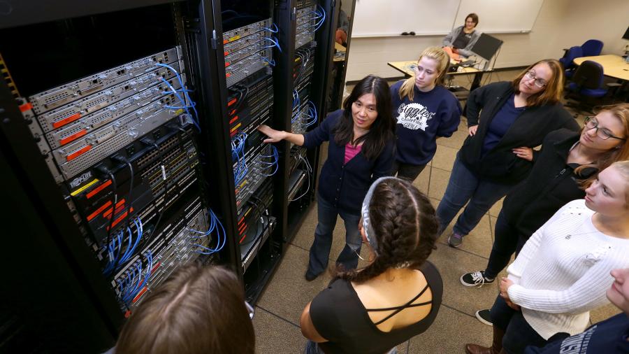 Professor Holly Yuan discusses computer servers with students, including Nikki Ruf, far right.