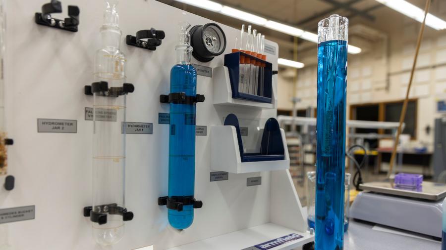 Vials of blue liquid in a fluid properties apparatus lab station