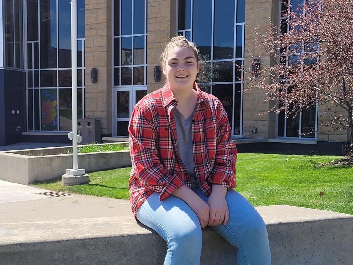 Stout Scholar Erin O'Brien seated outside the Memorial Student Center, spring 2021.