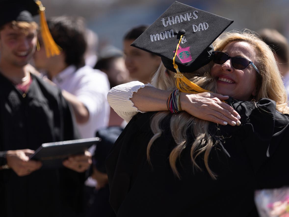 A graduate gets a hug after the spring 2022 commencement ceremony.