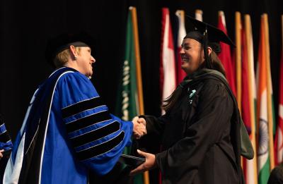 Jamie Stillion receiving her master's diploma from Chancellor Katherine Frank.